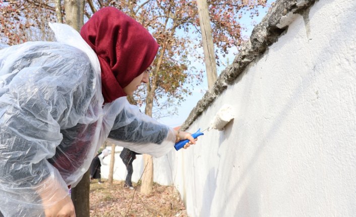 Çocuklar için okulun bahçe duvarlarını boyadılar